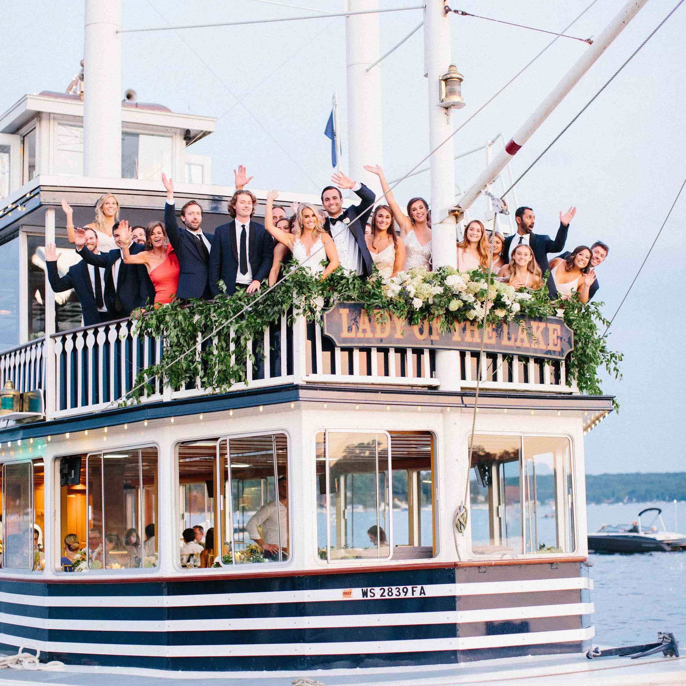 在湖夫人号甲板上挥手的婚礼派对