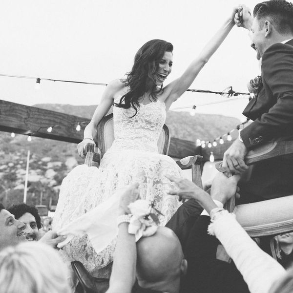 新郎新娘坐在椅子上”class=