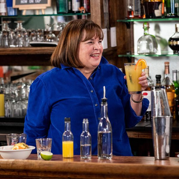 艾娜·加滕在酒吧里微笑着，手里拿着一杯橘子饮料