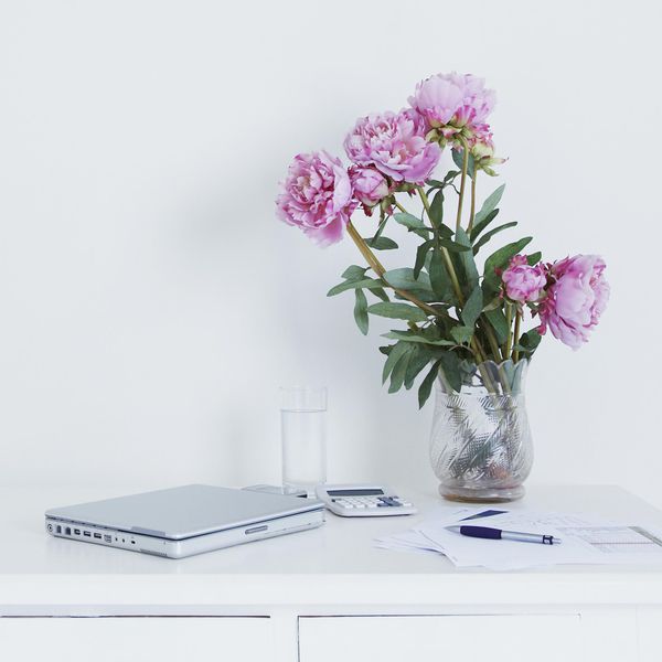 <p>桌子上的笔记本电脑和牡丹花束</p>
