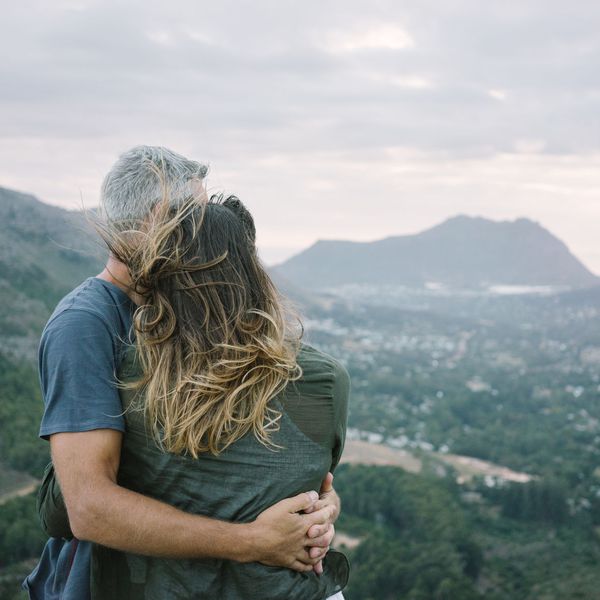 一对夫妇俯瞰着彼此拥抱的山