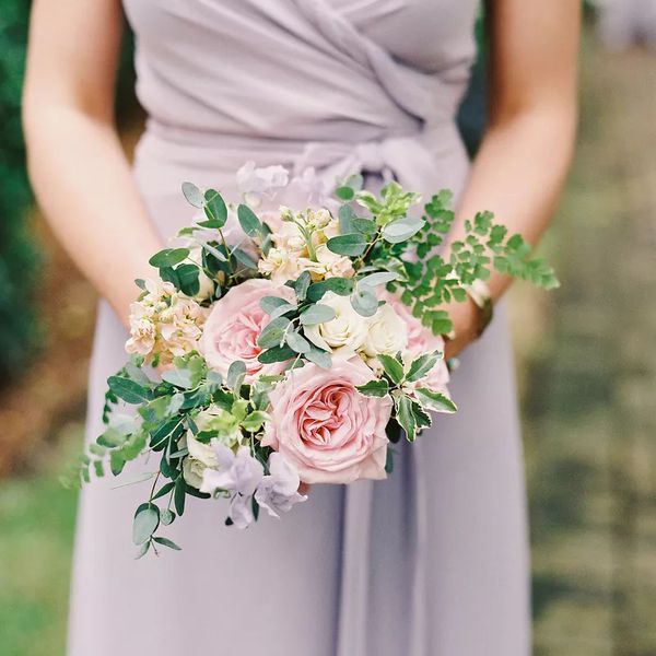 Holding a wedding bouquet in lavender dress