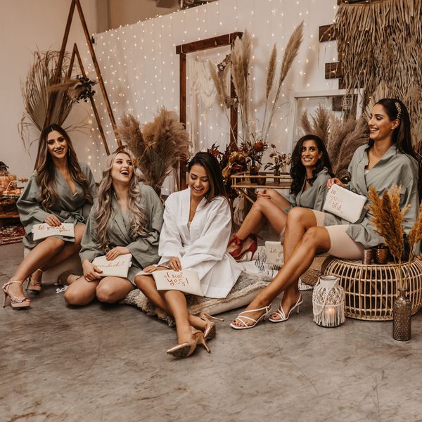 新娘队穿着礼服一起坐在垫子上