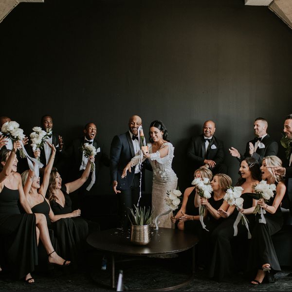 新娘和新郎弹出一瓶香槟被新娘派对包围