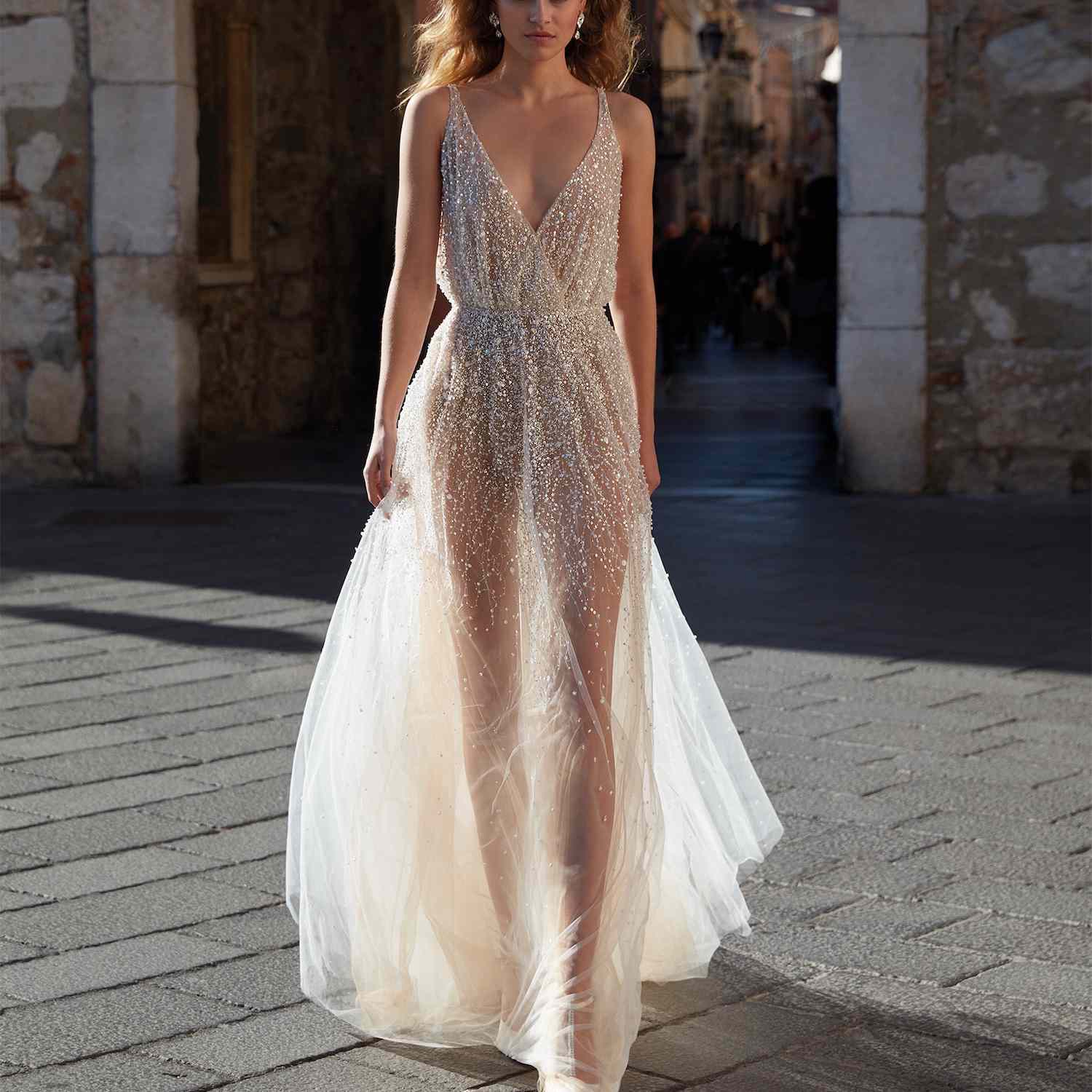 模型在半纯粹闪闪发光的连衣裙走在意大利街