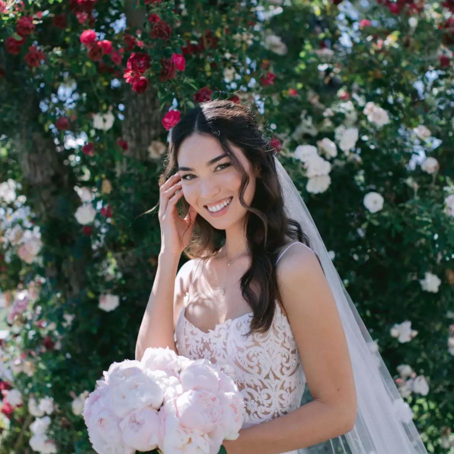 新娘微笑着捧着一束牡丹