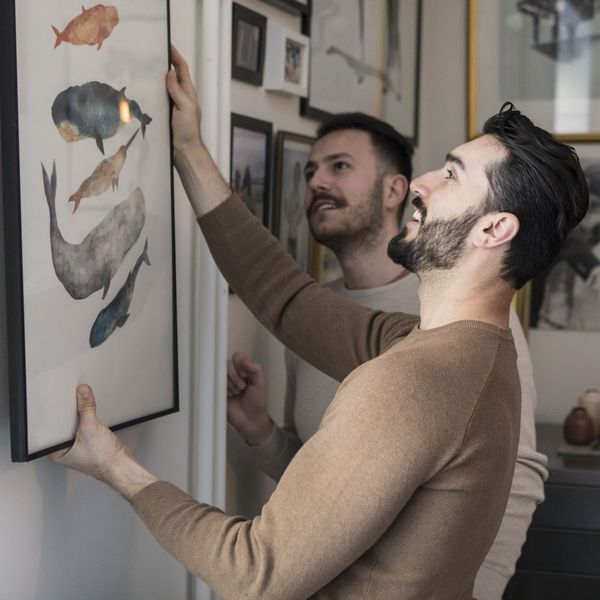 一对夫妇在墙上挂艺术品