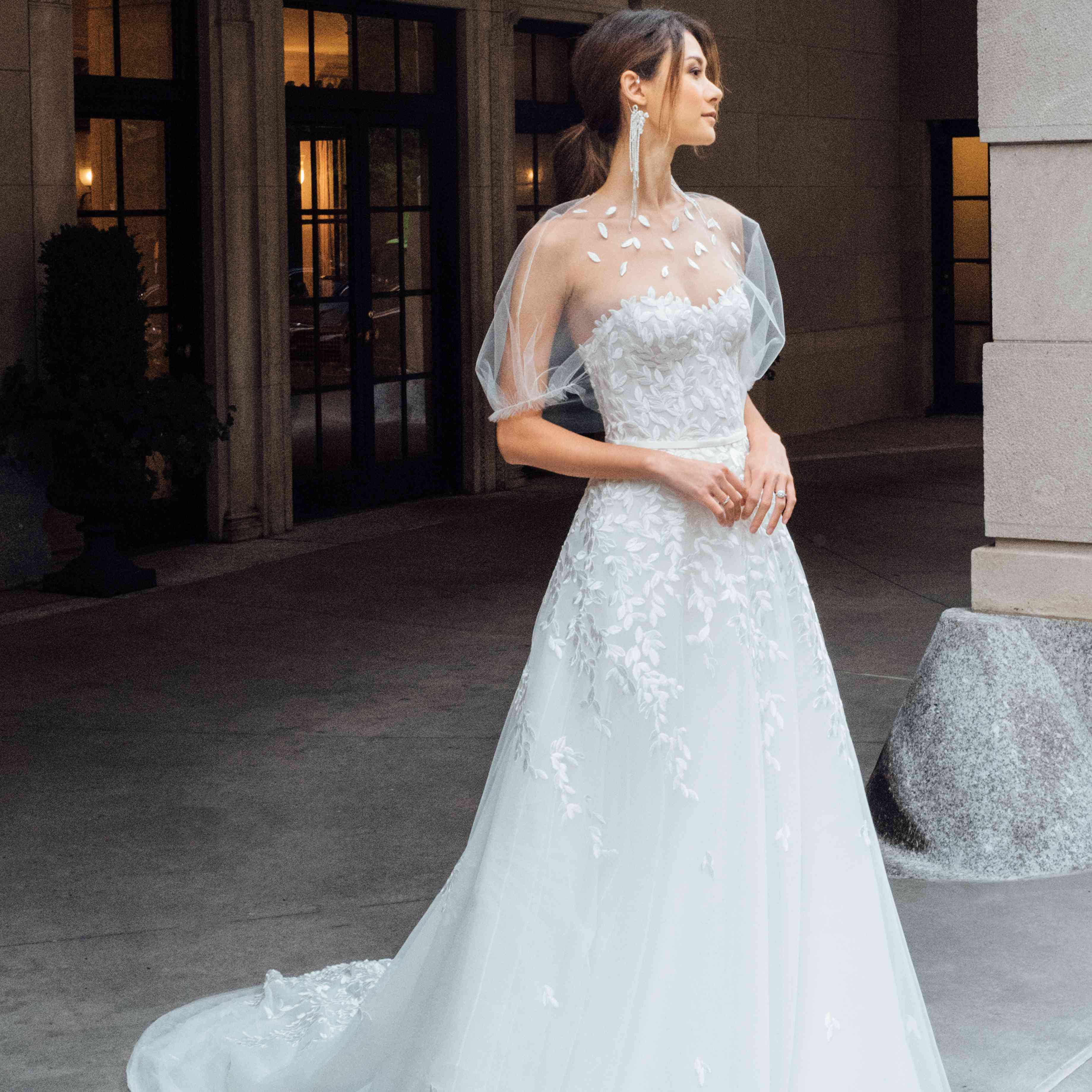 模型中与紧身胸衣和叶刺绣和匹配薄纱capelet A线袍。