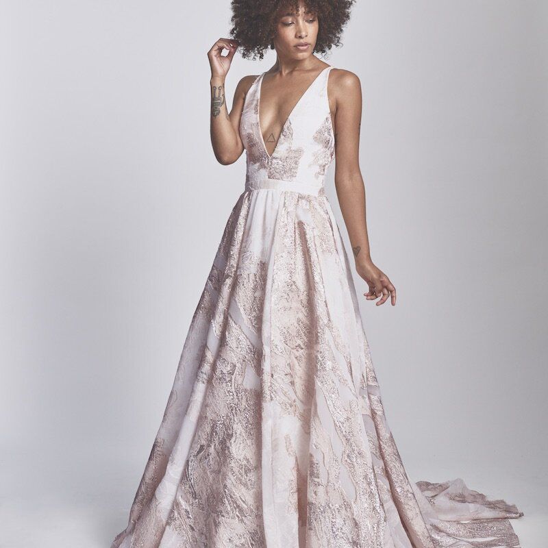 模特身穿粉色v领礼服，饰有金属光泽coupé