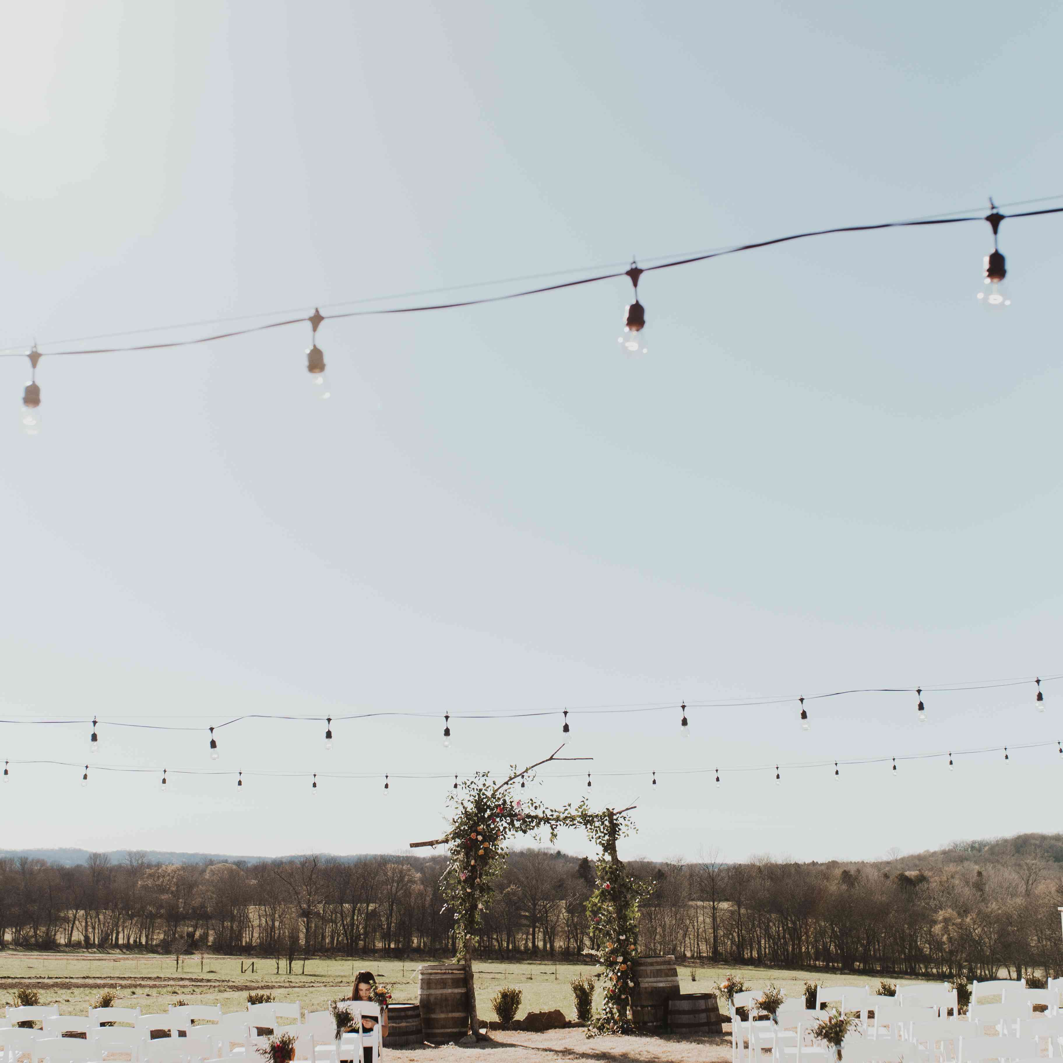 室外仪式，在过道上有串灯和分支拱门，两边都有桶