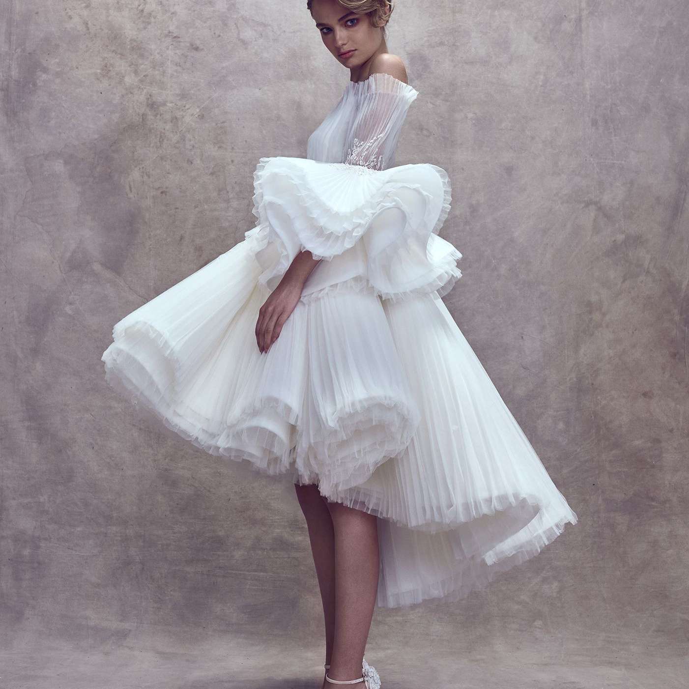 模特穿着露肩连衣裙，搭配高低层薄纱裙和超大袖