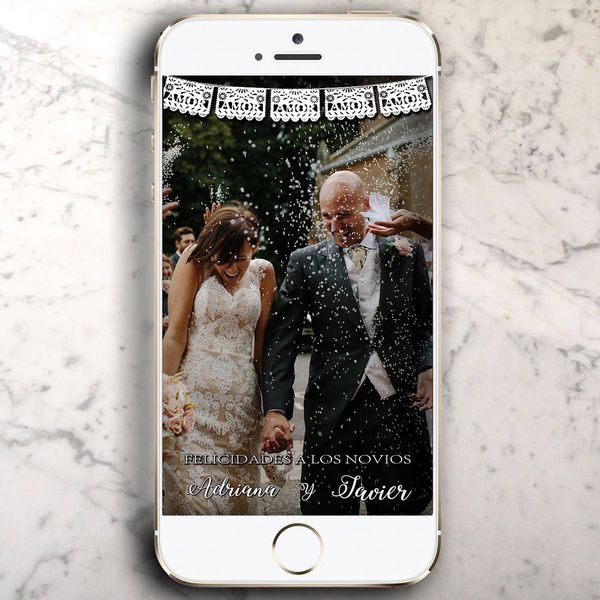 大理石台面上放着iPhone，还有一张结婚照和Snapchat上的地理滤镜