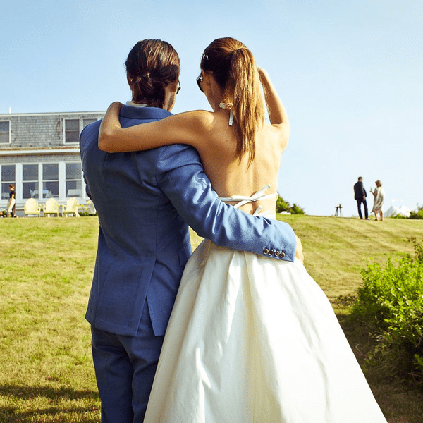 拥抱在草坪的新娘和新郎在他们的婚礼。