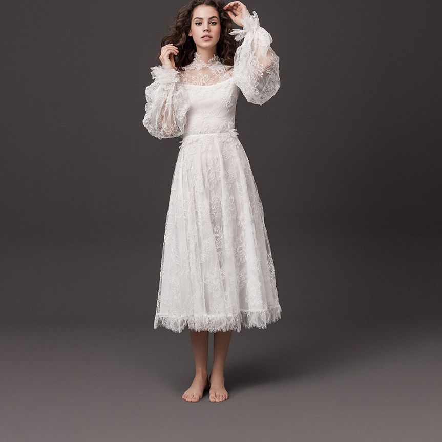 模特穿着茶色绣花长礼服，有泡泡袖和镶边