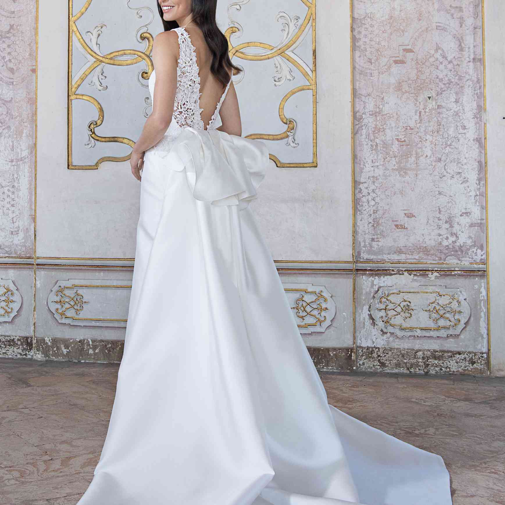 模型长礼服搭配蕾丝胸衣，V型背部和超大蝴蝶结