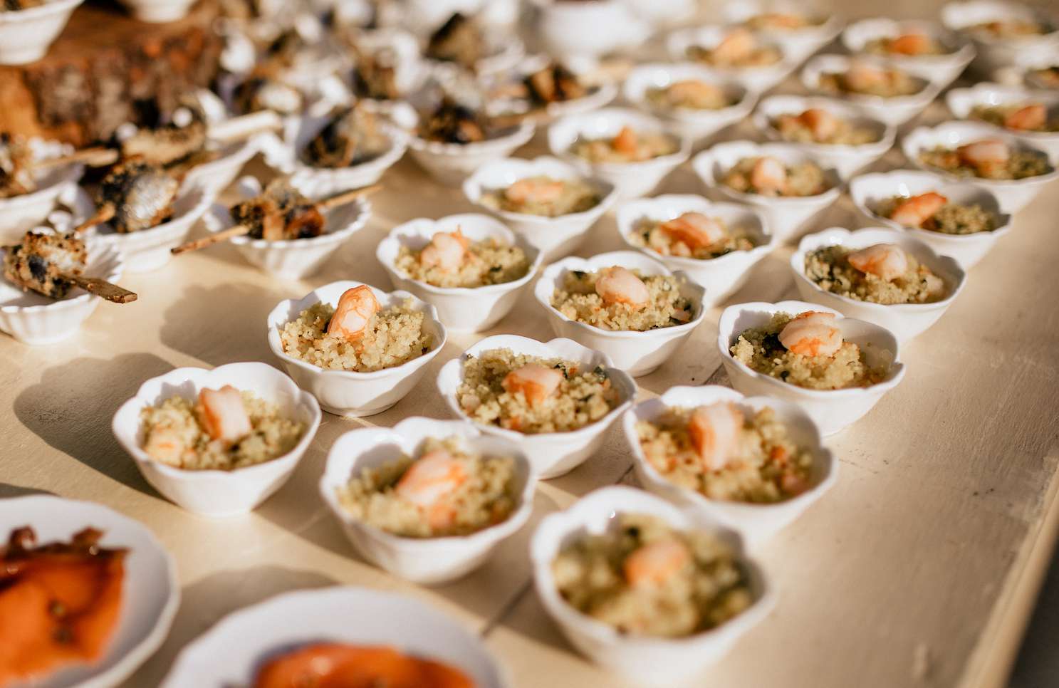 铺有虾的白色杯子的桌子，上面放满奎奴亚藜