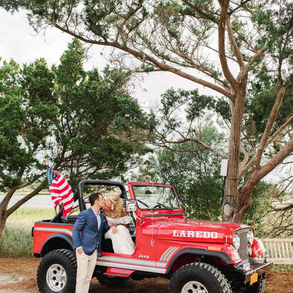 永恒的南方婚礼，新娘和新郎亲吻红色吉普车