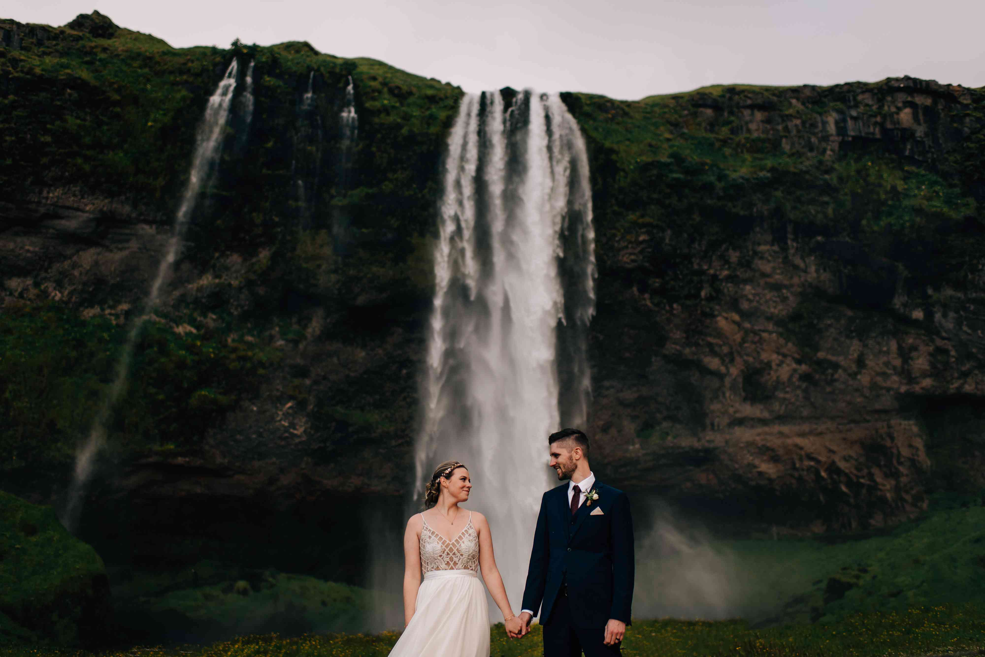 情侣手牵着手在冰岛瀑布前