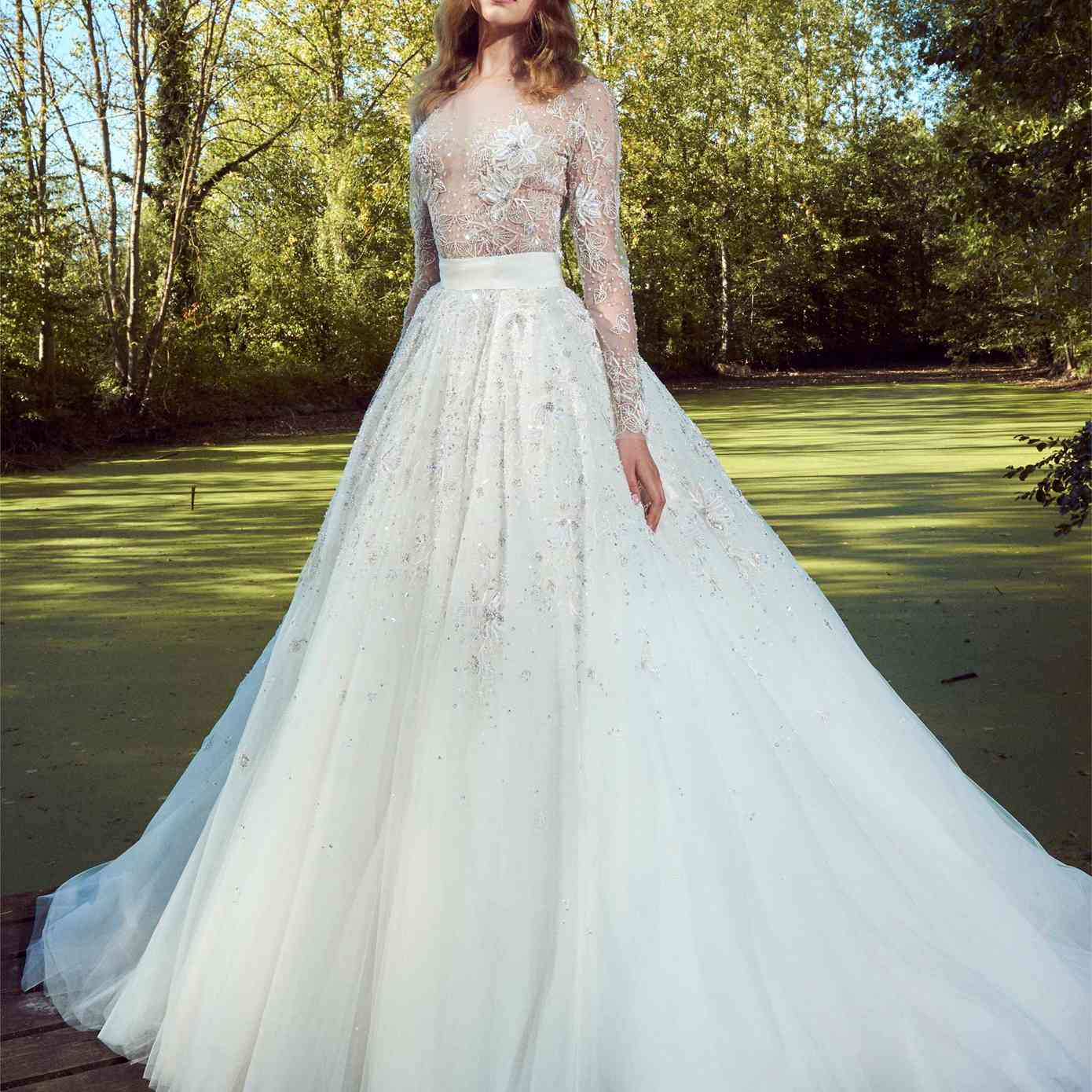 模型在舞会礼服长袖错觉紧身胸衣花卉刺绣和珠饰和大量的裙子与亮片和串珠刺绣