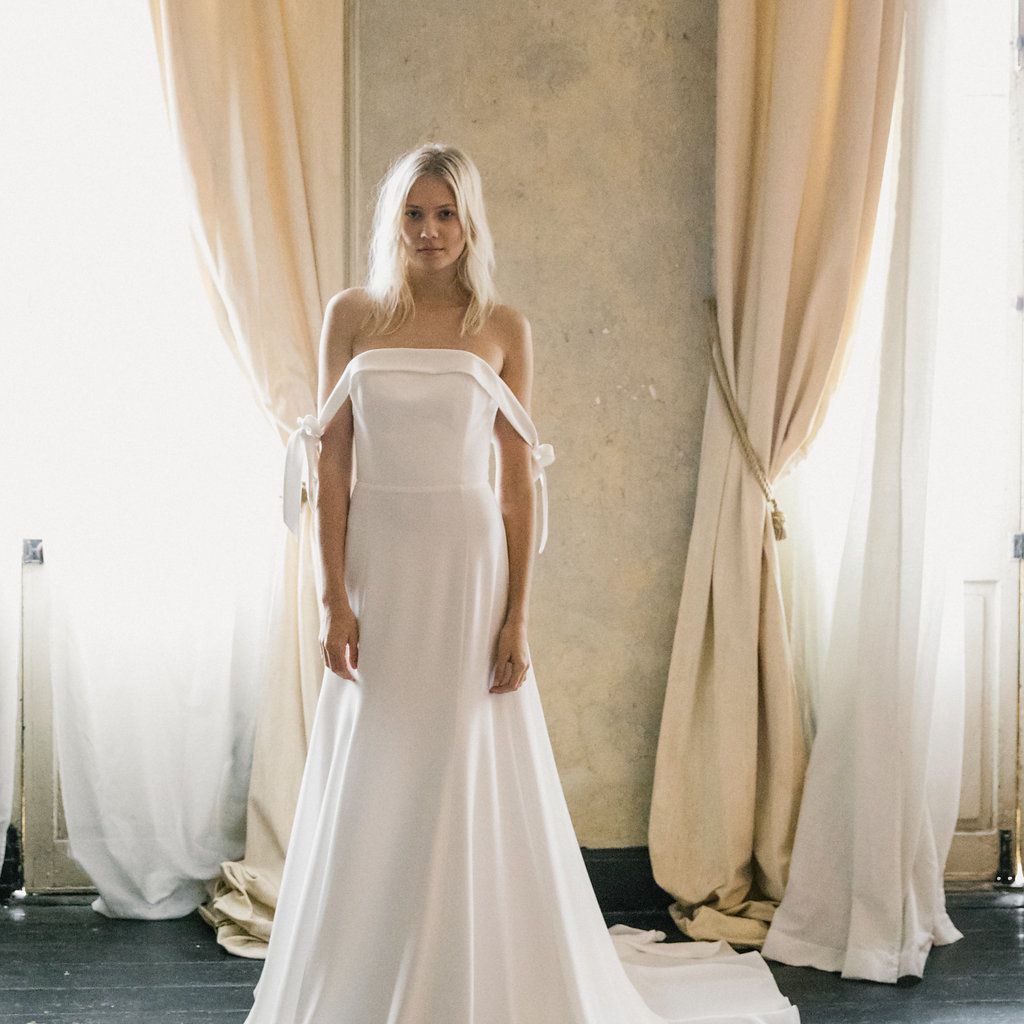 模特穿着白色礼服，露肩袖