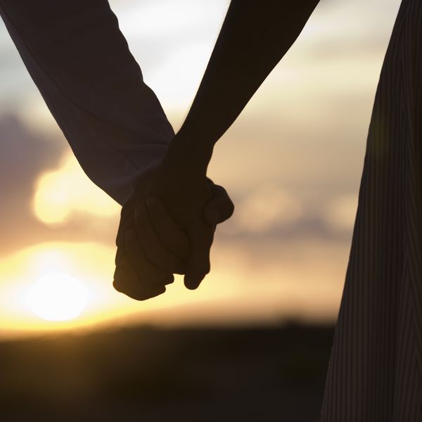 握手的成熟夫妇在日落，特写镜头