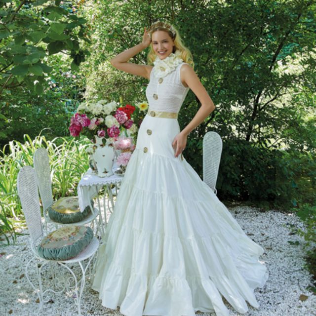 模特穿着金色纽扣的白色婚纱和闪光裙