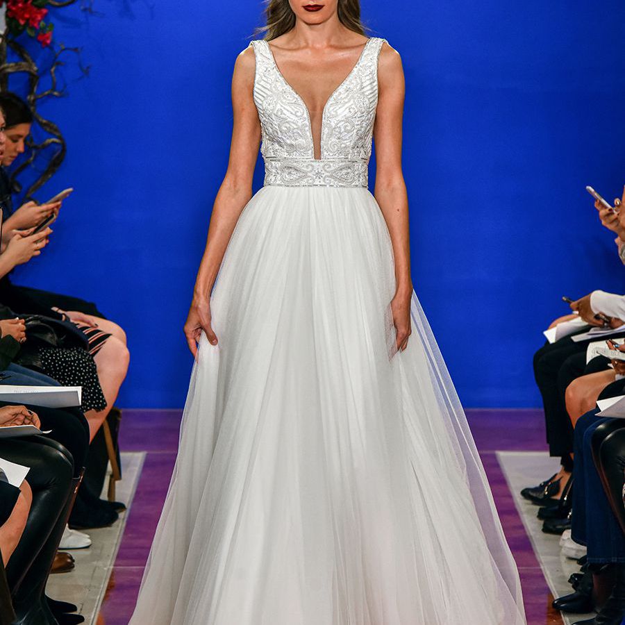 模型走在横向跑道的横向跑道与一块无袖的小珠绣胸衣与一个猛烈的领口