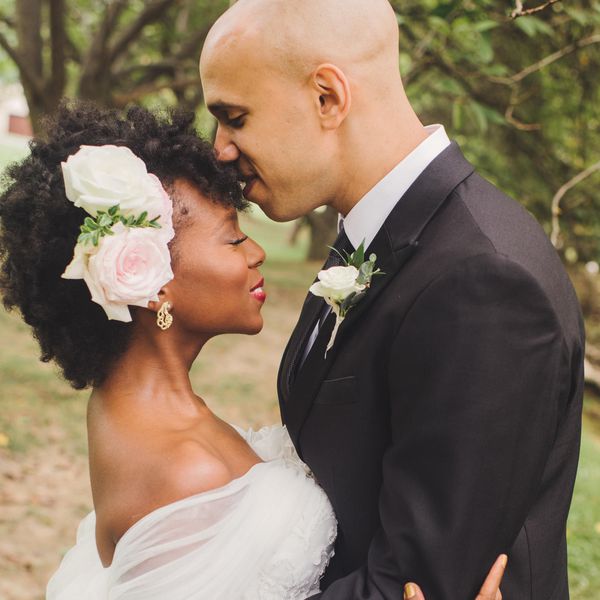 新娘头上戴着鲜花，新郎亲吻着她