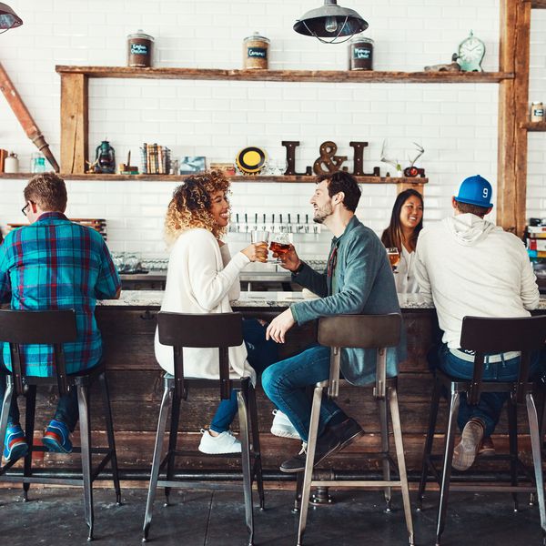 一对夫妇坐在拥挤的酒吧享受饮料。＂class=