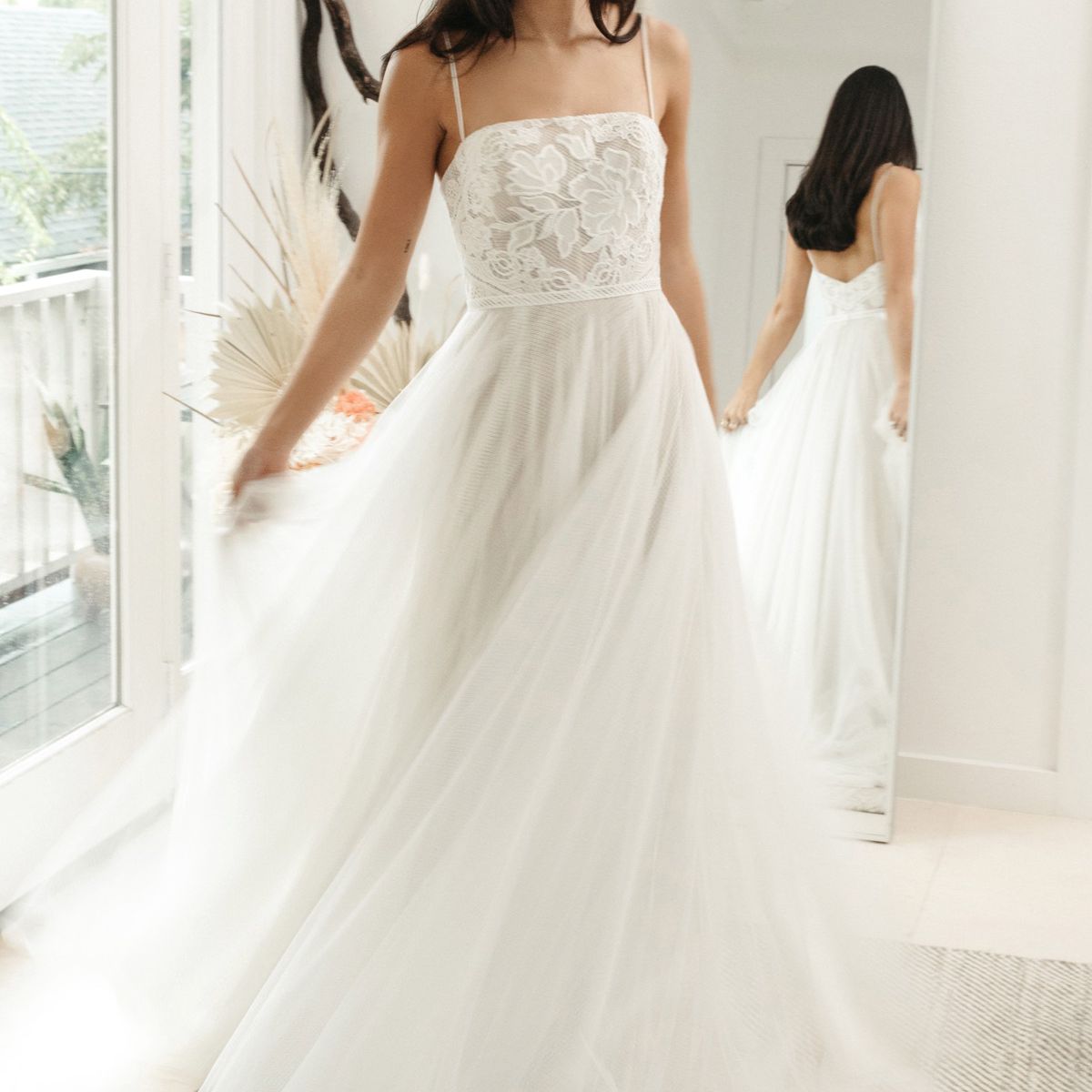 模特身穿无肩带a字裙，配蕾丝胸衣和薄纱裙