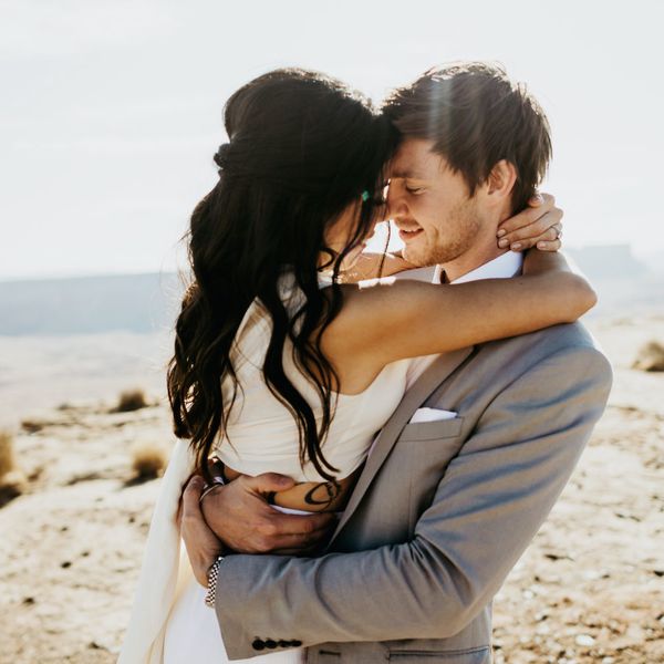 新娘和新郎在沙漠中拥抱。