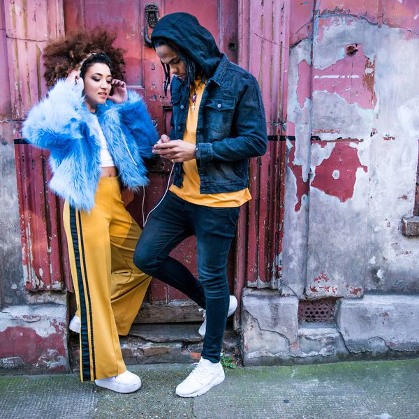 一对夫妇靠在楼上，通过耳机听音乐