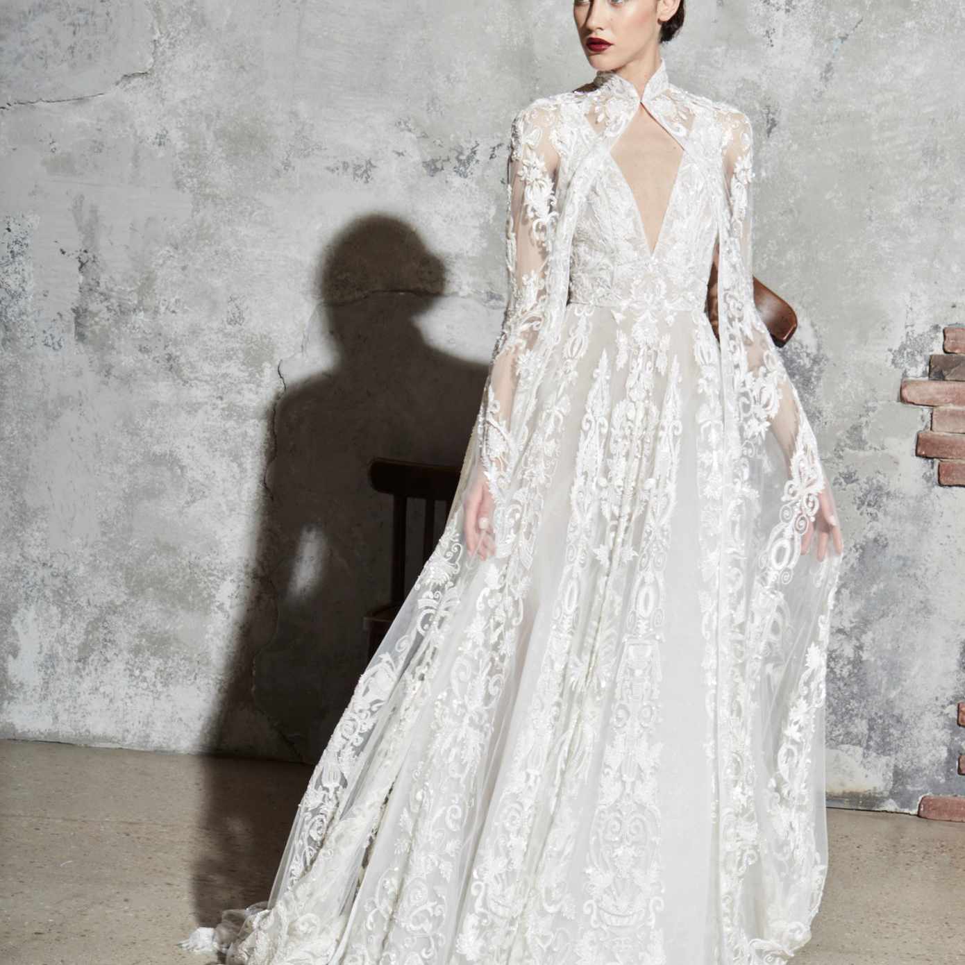 模型在无袖v领绣薄纱礼服匹配的披肩