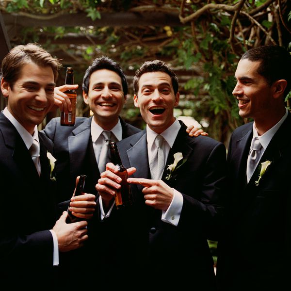 四个穿燕尾服的男人边喝啤酒边笑