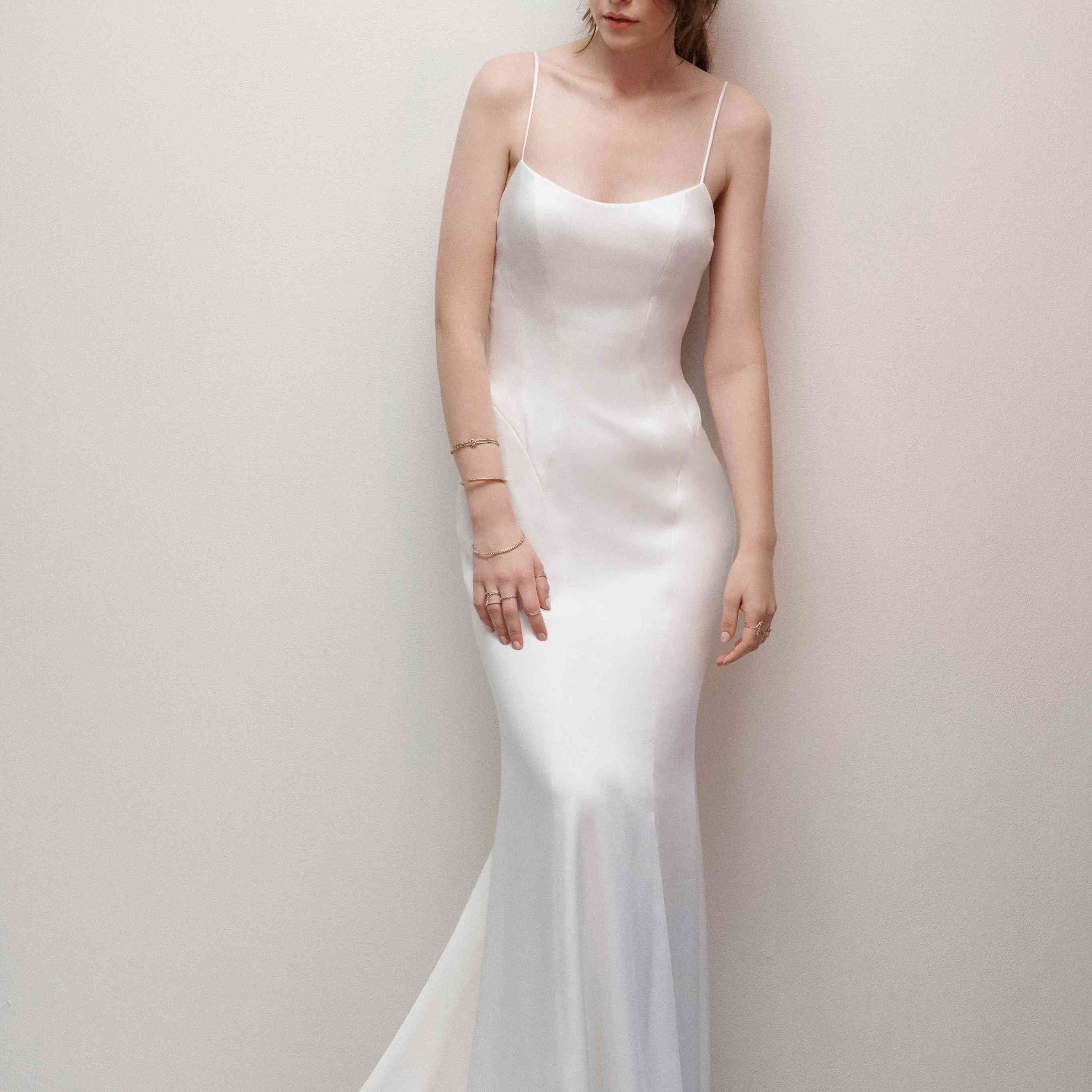 模特身着简单的丝质贴身礼服，搭配意大利面条绑带