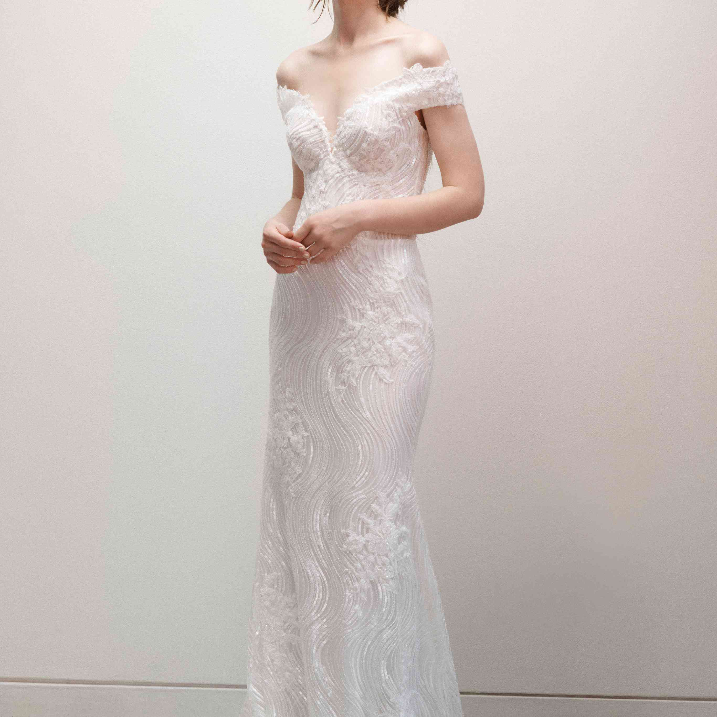 在场外的肩婚纱礼服亮片和装饰花卉示范