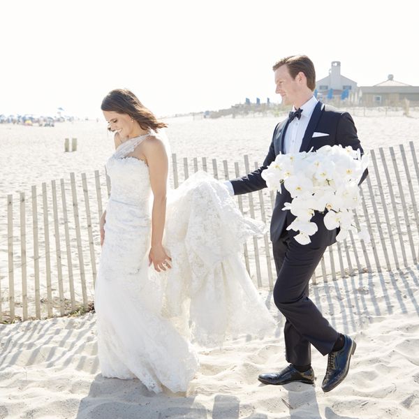 Bride and groom walking in sand