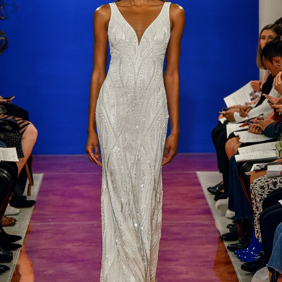 佩带无肩带鞘褂子​​的跑道的模型与V领和串珠刺绣