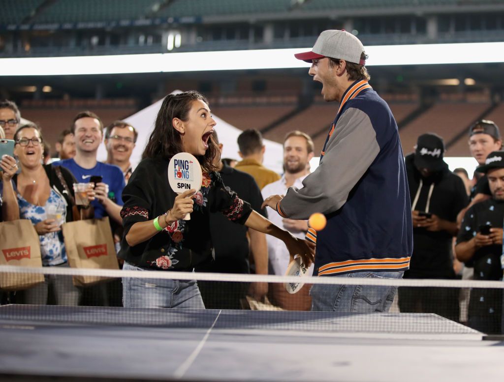 2018年8月23日，加州洛杉矶，米拉·库尼斯和阿什顿·库彻在克莱顿·克肖举办的第六届年度乒乓球比赛上打乒乓球。