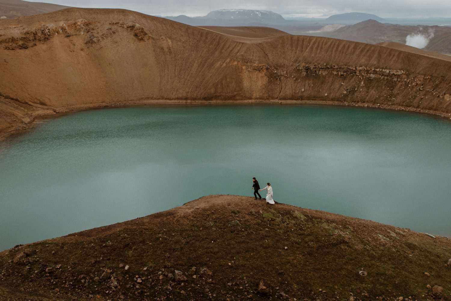 冰岛维提火山口的一对夫妇手牵手