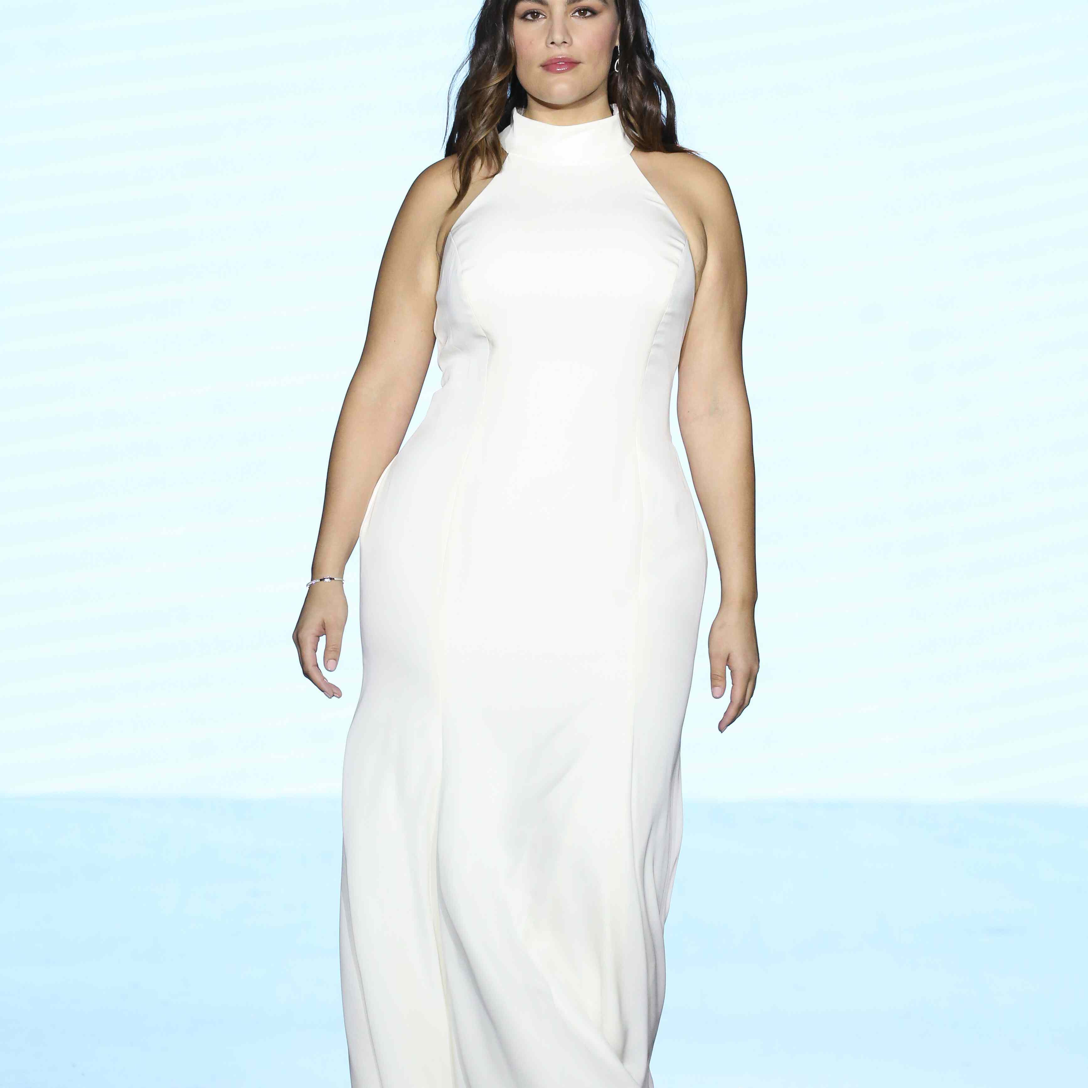 模特在跑道上合身的高领缎鞘礼服